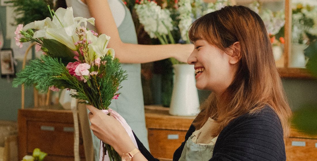 Fleuriste composant un bouquet dans sa boutique